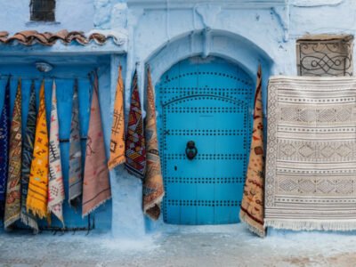 Moroccan rugs hanging near a door in Chefchaouen
