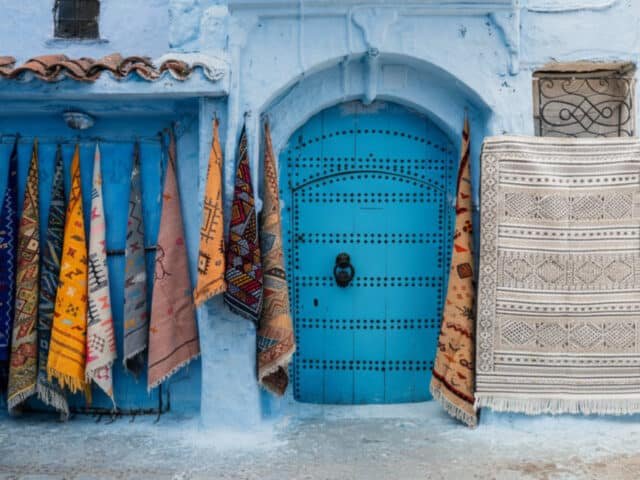 Moroccan rugs hanging near a door in Chefchaouen