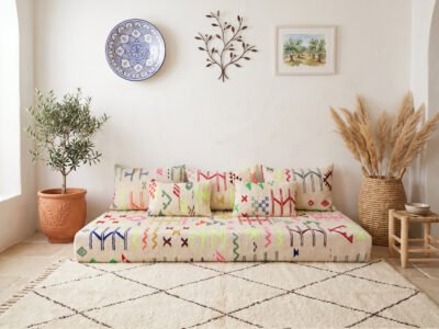 Colorful kilim floor sofa with Amazigh symbols on ivory cream ground, styled over Beni Ourain rug – Asala Living