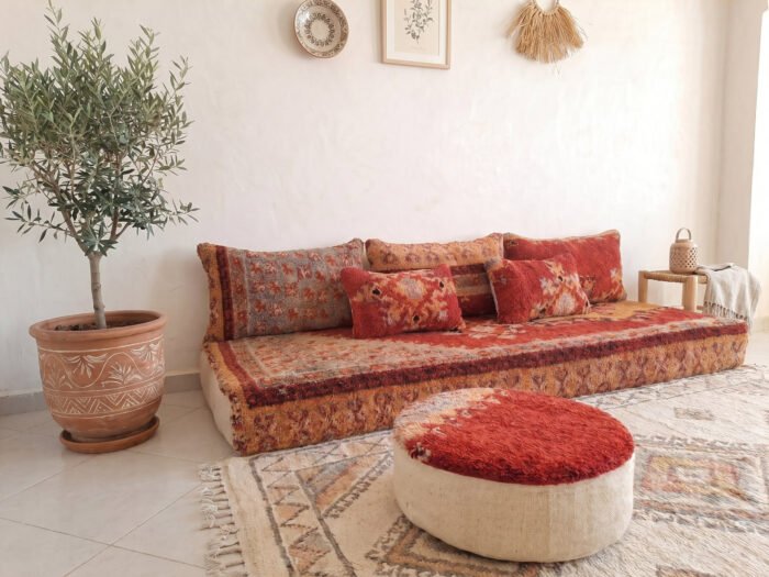 Vintage Boujaad red floor sofa set showing geometric tribal border, matching pouf and backrest cushions