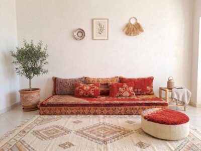 Vintage Boujaad red floor sofa set with crimson pile cushions on Berber rug, tadelakt wall