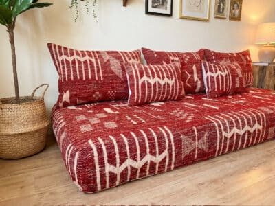 Berber kilim flatweave detail on deep red floor sofa – abstract cream geometric motifs – Asala Living