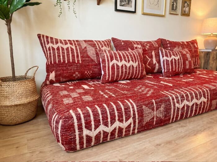 Berber kilim flatweave detail on deep red floor sofa – abstract cream geometric motifs – Asala Living