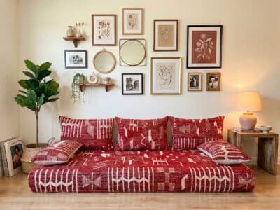 Deep red Berber kilim floor sofa with matching cushions in a boho living room – Asala Living