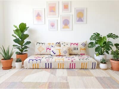 Ecru flatweave floor sofa with multicolor Berber motifs in a bright boho living room – Asala Living