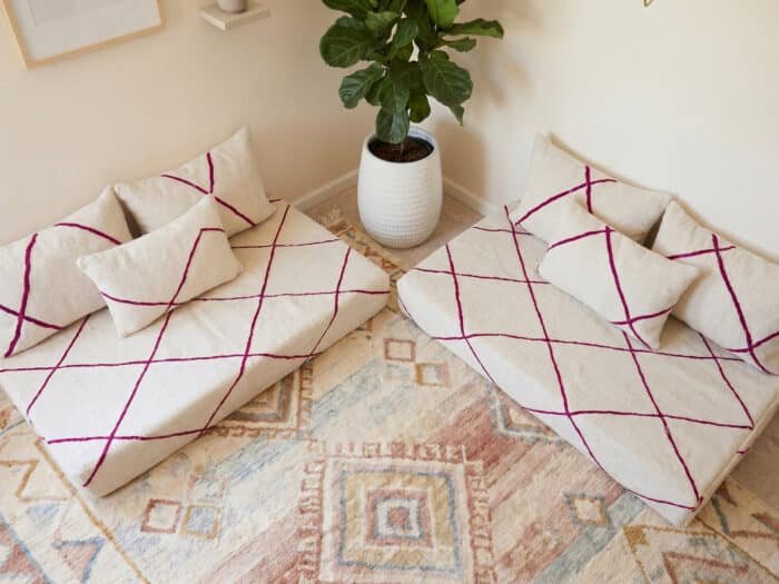 Overhead view of fuchsia diamond Berber floor sofa set on a vintage Moroccan rug beside a fiddle-leaf plant