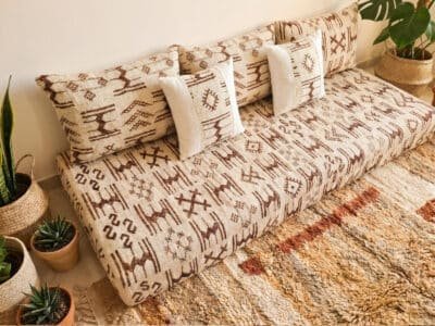 Ivory Azilal wool pile sofa close-up showing abstract brown Berber symbols and white linen accent pillows