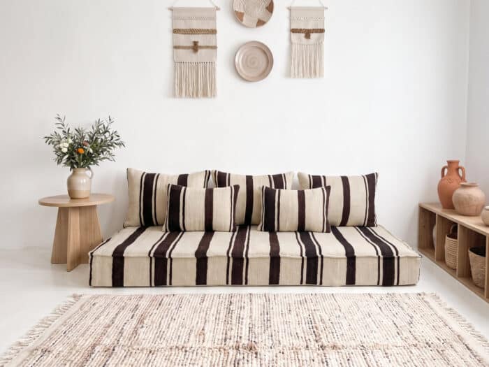 Brown striped kilim floor sofa with five cushions in a bright bohemian Moroccan living room