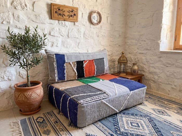Color block hanbel floor sofa styled at an angle beside a brass lantern and olive tree – Asala Living