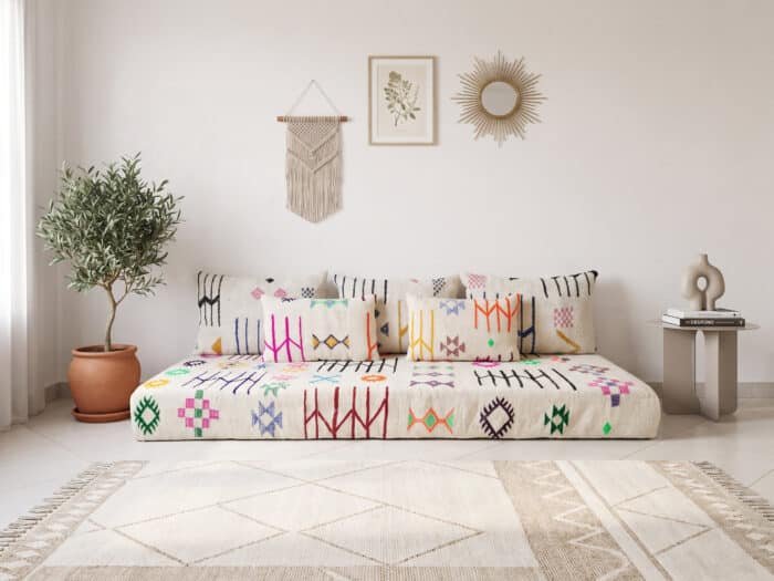 Moroccan floor sofa with symbols in ivory, styled with matching Berber cushions in a bright boho living room