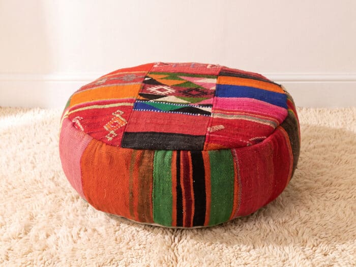 Bohemian Floor Pouf with geometric kilim top and bold striped sides on a cream shag rug