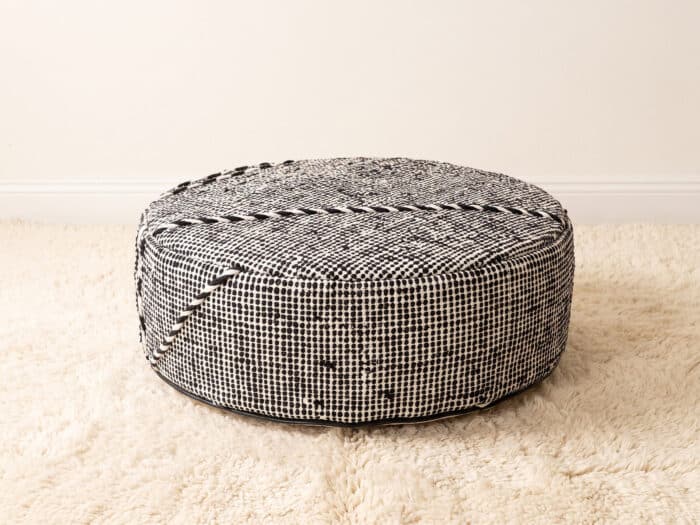 Morocco Black and White Ottoman round cotton pouf styled on an ivory shag rug