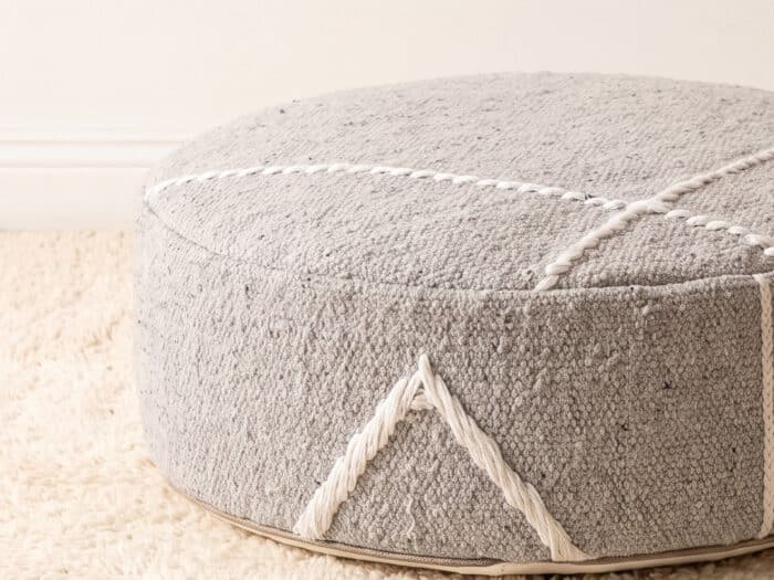 Morocco Light Grey Ottoman close-up showing heathered grey weave with white Berber cord and tassel