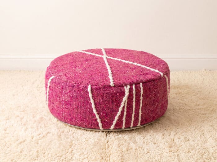 Morocco Pink Ottoman round cotton pouf styled on an ivory rug