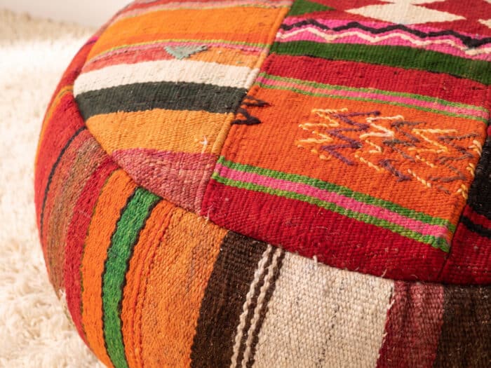 Close-up of Patchwork Kilim Pouf showing orange, red and green kilim panels with embroidered star detail