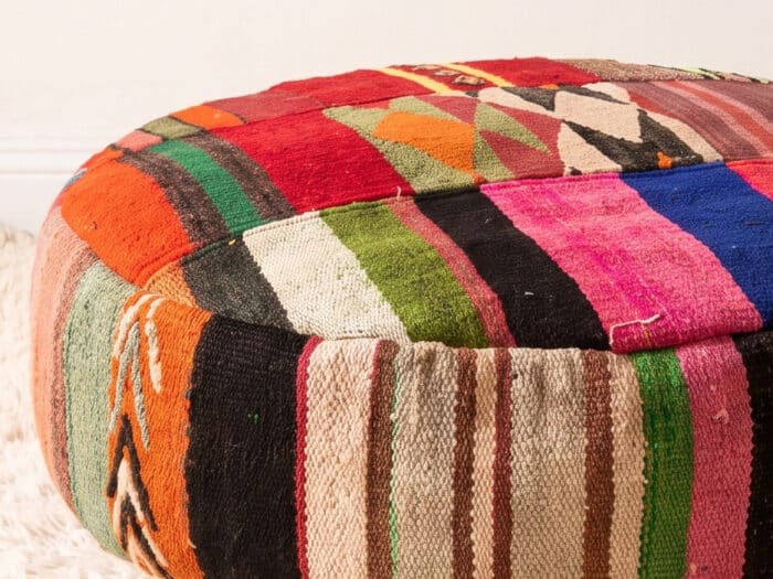 Close-up of Vibrant Floor Pouf showing pink, blue and green striped kilim panels and earthy sides