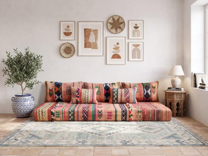 Vintage terracotta floor sofa styled in a white Moroccan living room with back cushions and olive tree