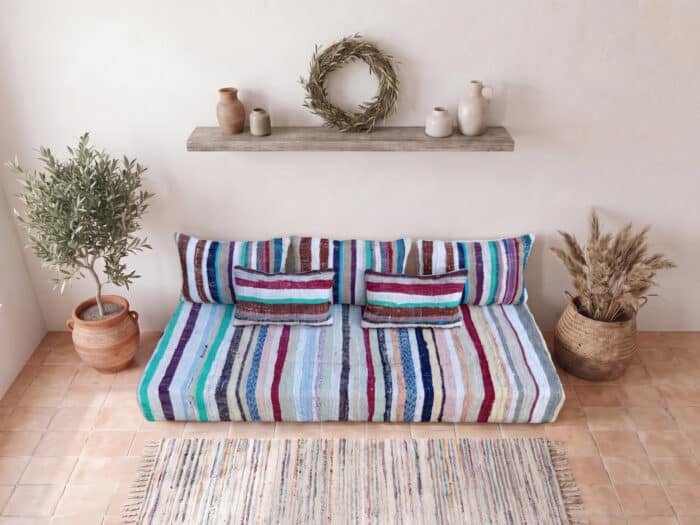 Pastel stripe floor sofa with striped back and lumbar pillows in a boho Moroccan room
