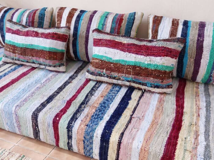 Pastel stripe floor sofa in recycled cotton, close view of turquoise, burgundy and ivory rag-weave stripes