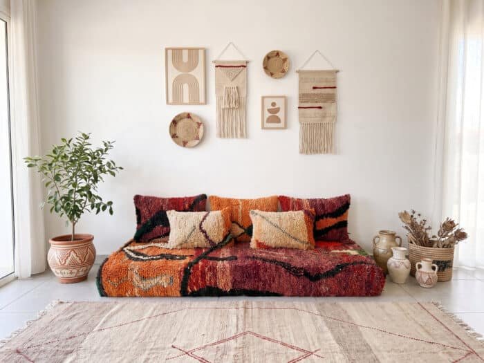 Sunset Moroccan floor sofa set, front view below macramé wall hangings and woven baskets