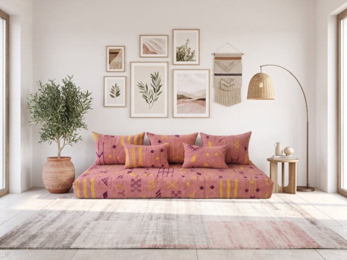 Terracotta majlis sofa with mustard and plum Berber symbols beside a potted olive tree
