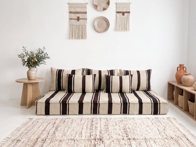 Brown striped kilim floor sofa with five cushions in a bright bohemian Moroccan living room