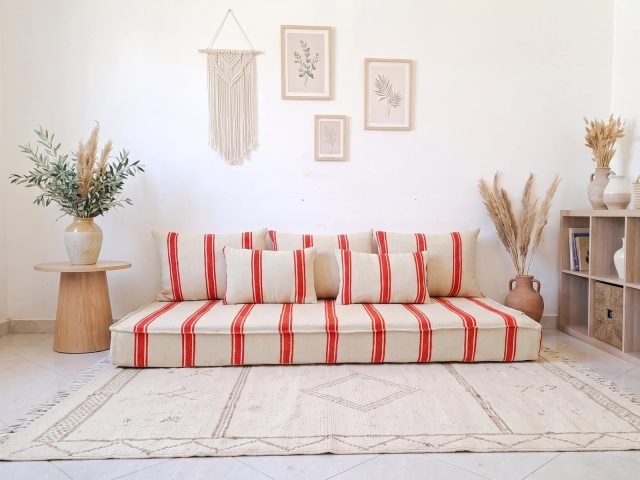 Orange stripe hanbel floor sofa in ivory wool styled with five pillows in a bright Moroccan living room
